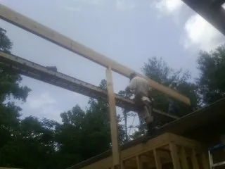 Carpenter setting a ridge beam over a new addition frame — Ice Dam Removal by Roofing Brothers in Madison